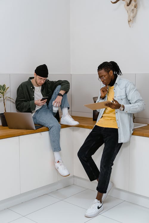 Free Men Sitting in a Counter Using Electronic Devices Stock Photo