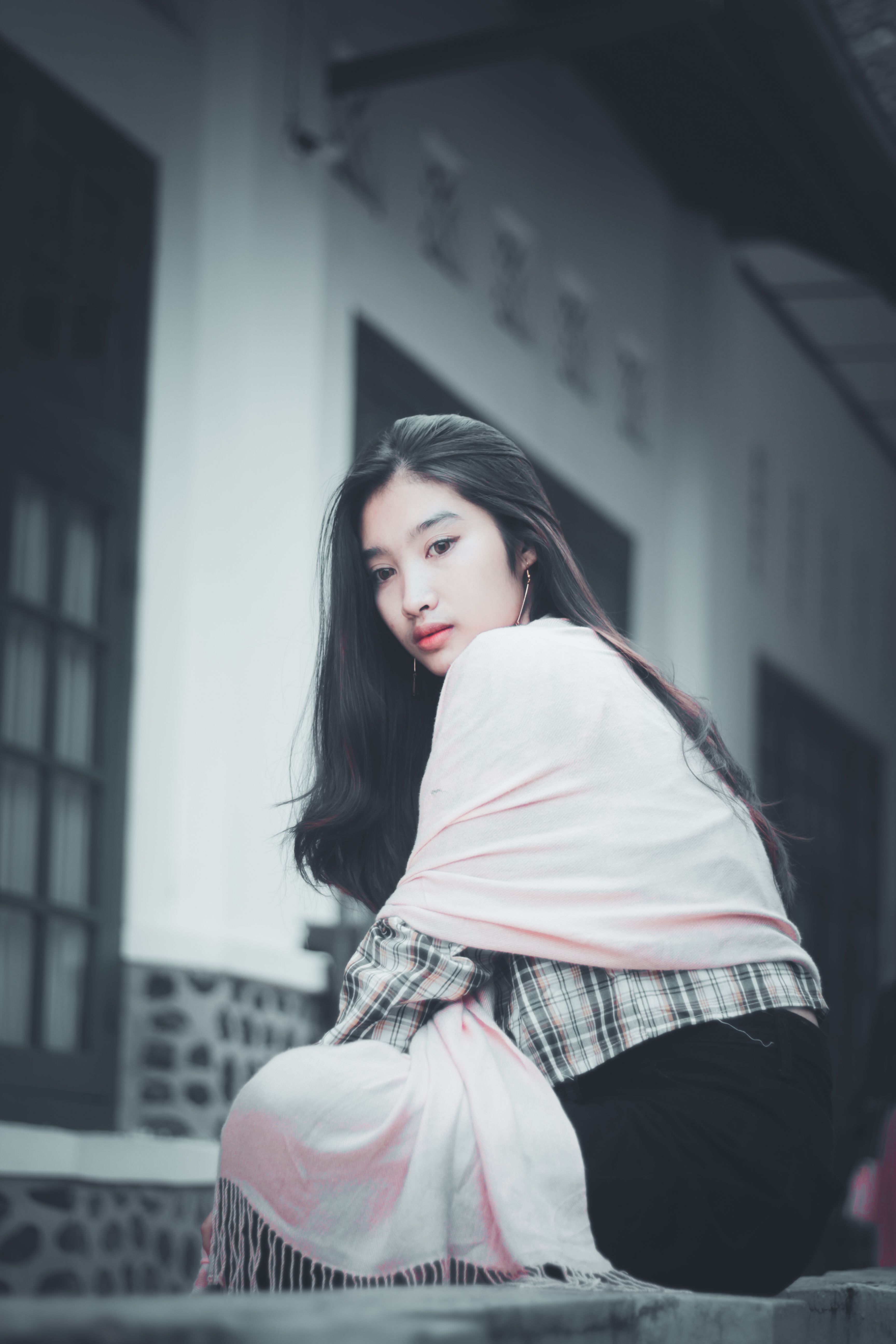 Beautiful Woman Sitting on Concrete Surface · Free Stock Photo