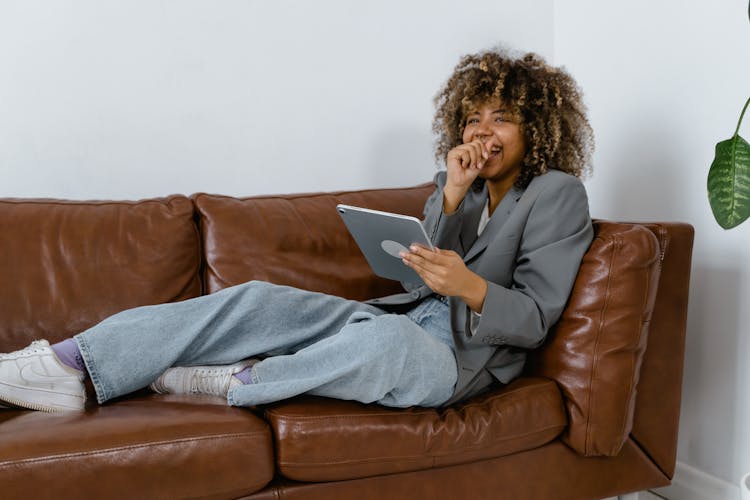 Woman In Gray Blazer Sitting On Brown Leather Sofa