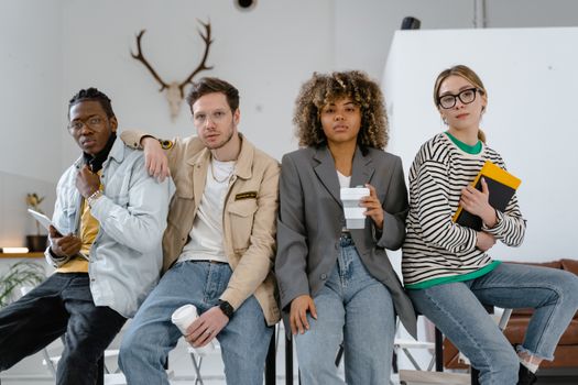 A diverse group of young professionals enjoying a casual moment in a stylish office environment.