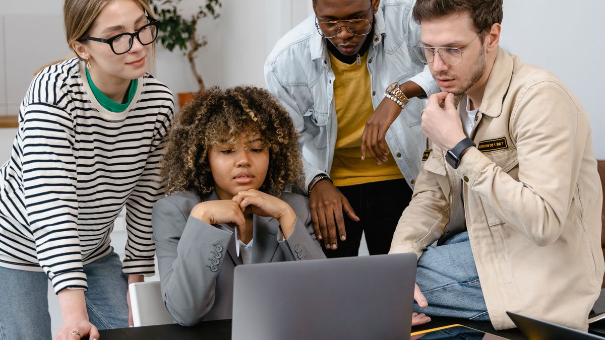 Team collaborating with laptops and notebooks, relevant to no-code migration planning