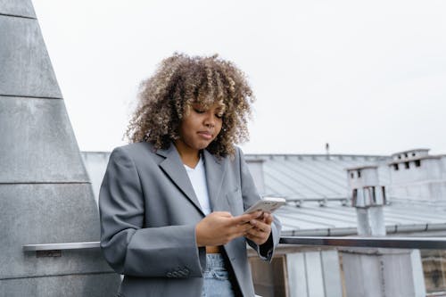 Woman with Curly Hair Holding Smartphone