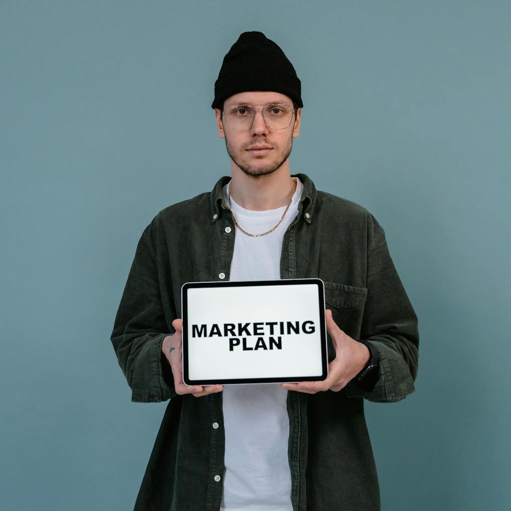 Man holding tablet with 'Marketing Plan' on screen. Gemini Digital Marketing.