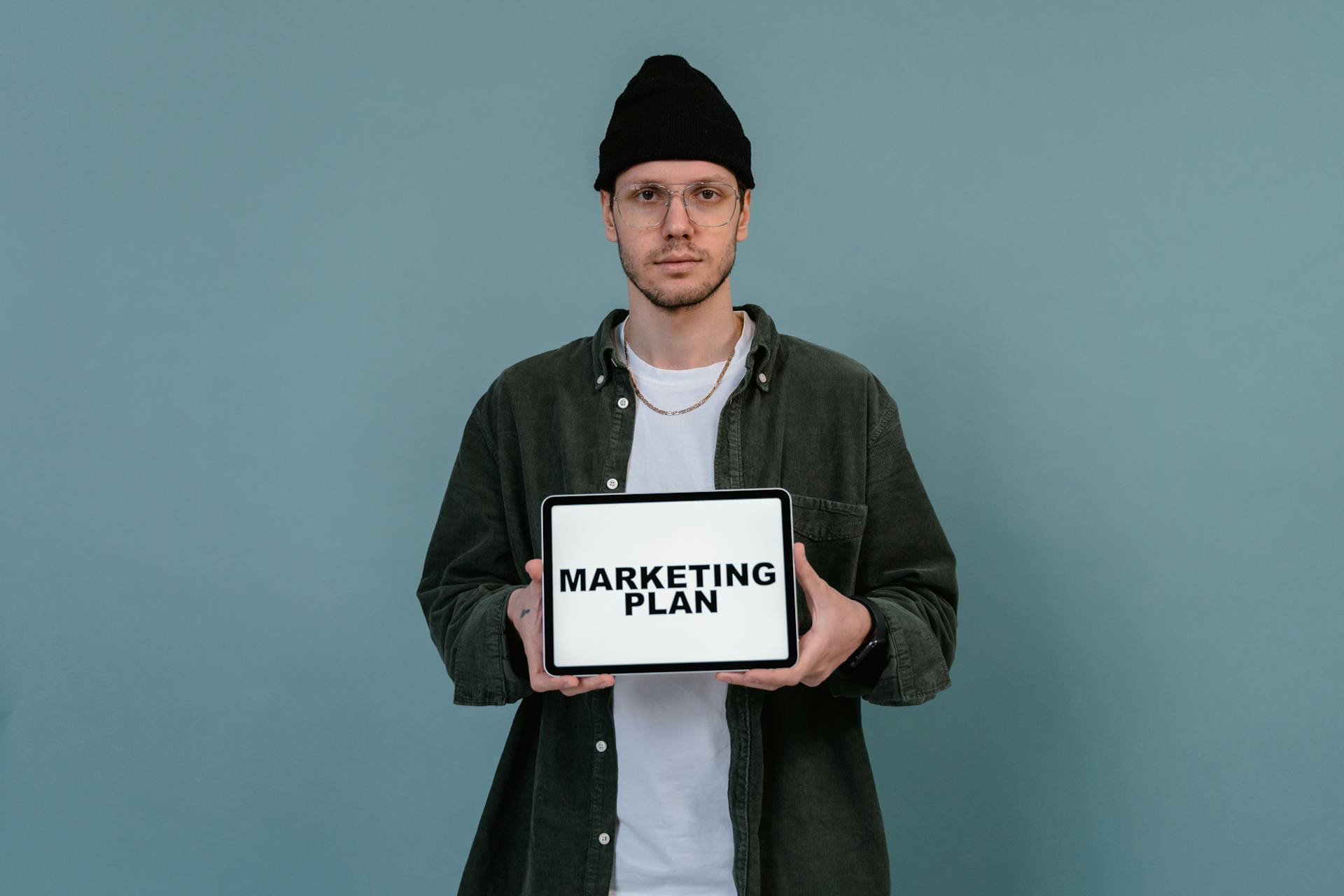 Man in Black Beanie Hat Holding White Tablet Computer with Message