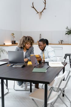 Two professionals working together in a bright, modern office space.