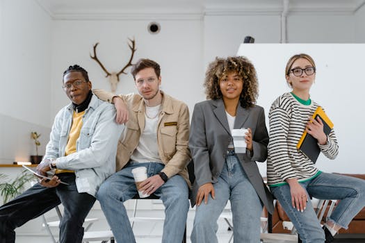 A diverse group of young professionals casually posing inside a modern office setting.