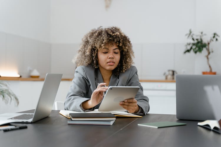 Woman In Gray Long Sleeves Browsing On The Ipad 