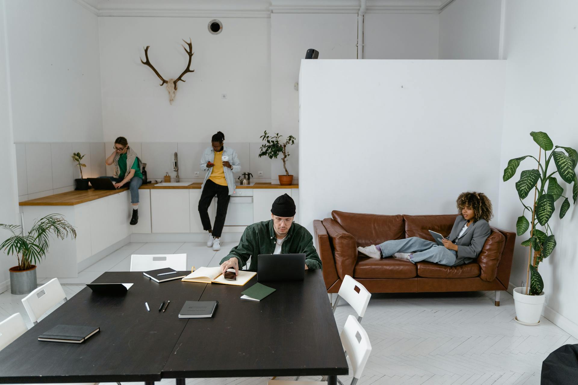 Diverse team working in a modern office, utilizing digital devices for collaboration