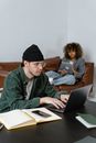Man in Green Jacket Using Macbook