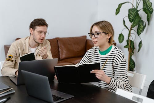 Free Man and Woman Discussing in Workplace Stock Photo