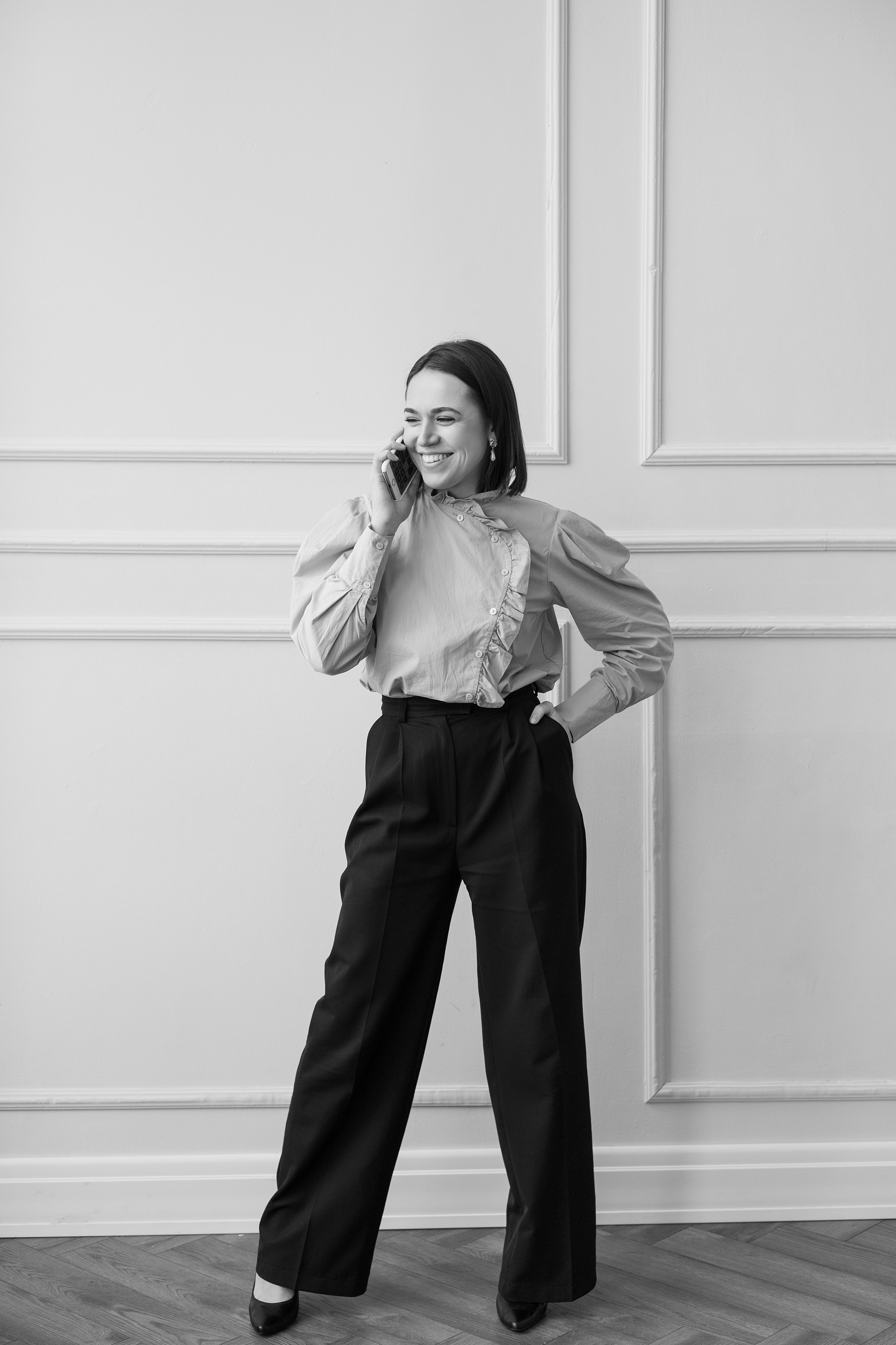 Woman in White Dress Shirt and Black Pants Standing Beside White Wall ...