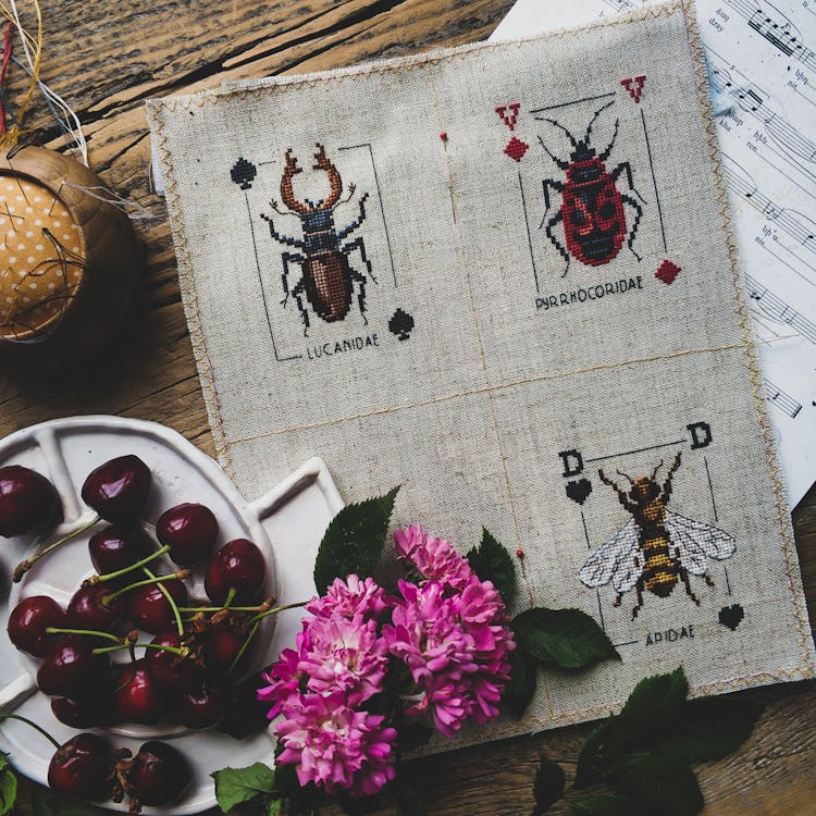 Cloth With Insect Illustrations And Cherries Near Flowers