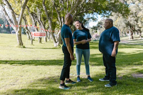 People In Blue Crew Neck Shirts Standing On Green Grass Field