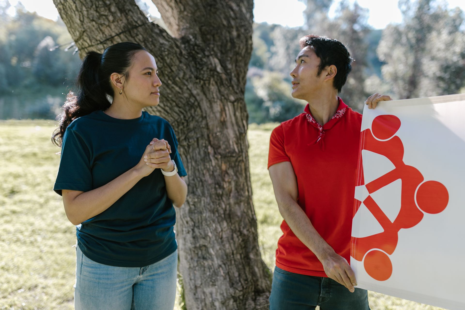 Two adults engaged in a team-building exercise outdoors on a sunny day.