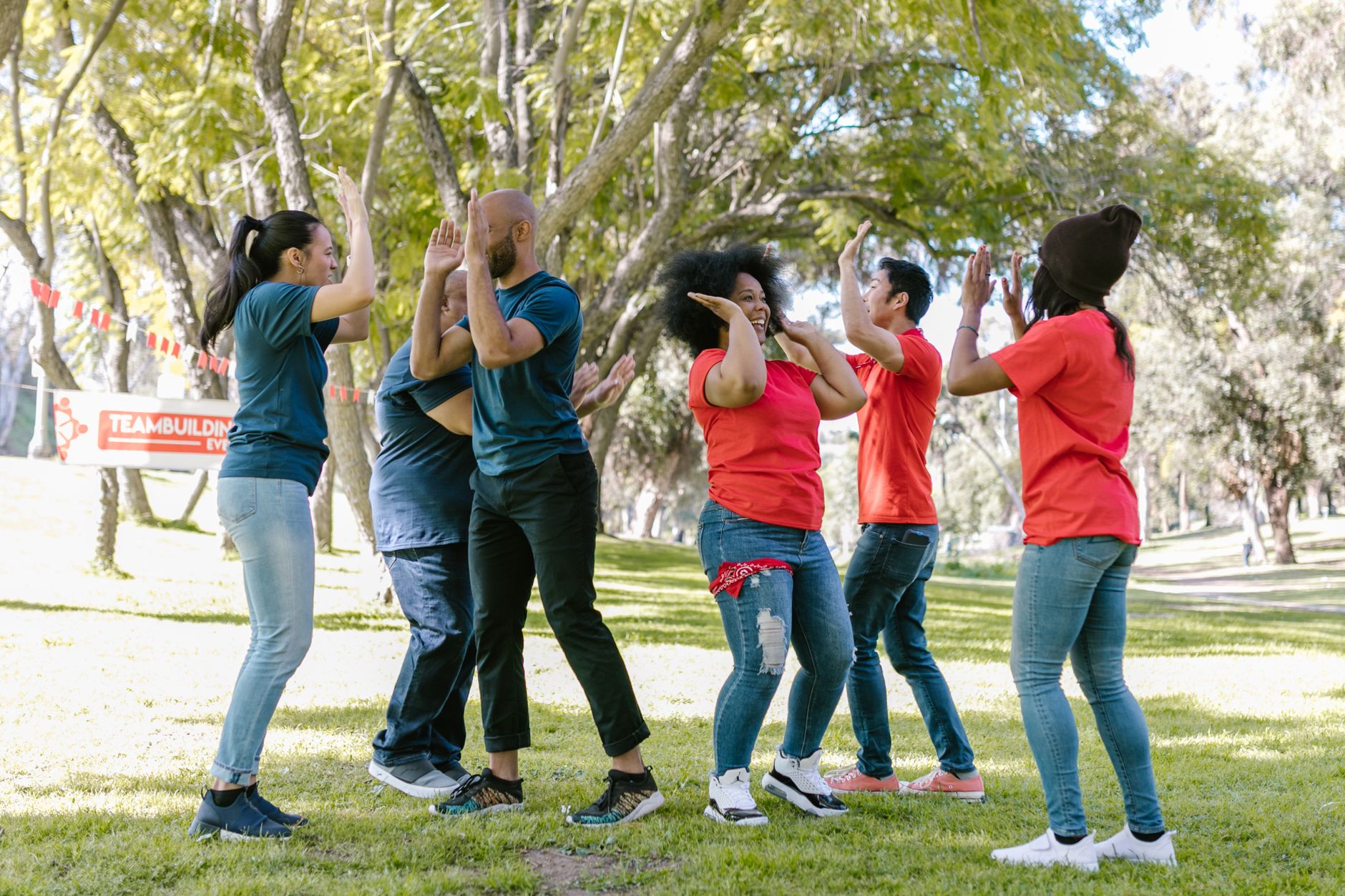 An office team celebrating together with smiles and high-fives.