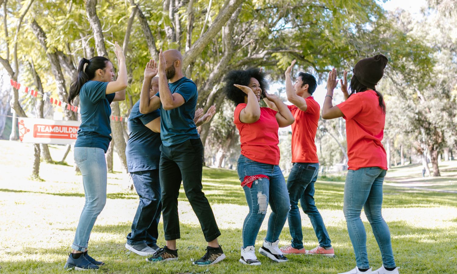 Grupo de empleados participando en una dinámica de team building al aire libre