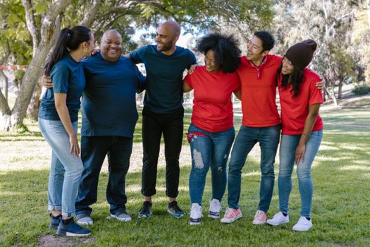 Happy diverse group of friends bonding and smiling together in a sunny park.