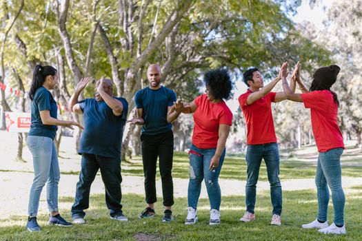Multicultural team engaging in outdoor team building exercises in a park setting.