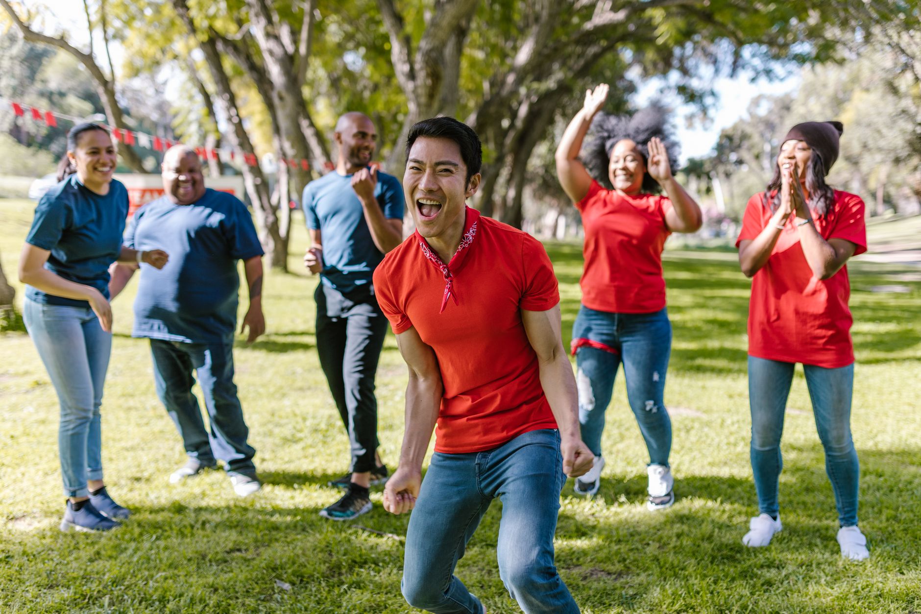 outdoor team building north coast — Group of happy adults playing and bonding in a park during a fun team building event.