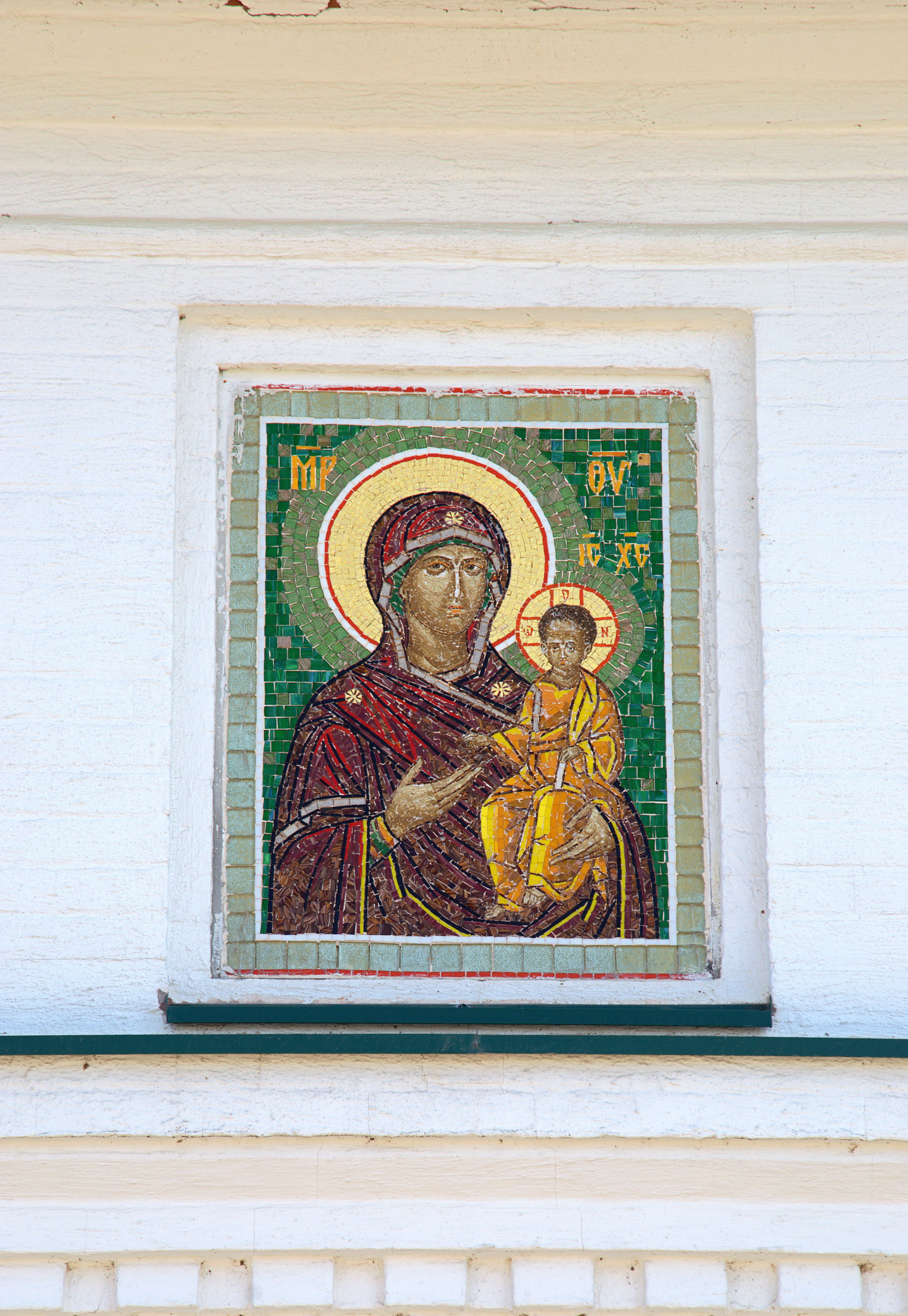 Intricate mosaic depicting Virgin Mary and Jesus, highlighting religious art on a church exterior.