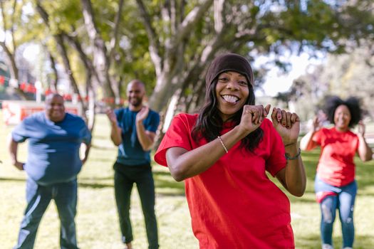 A group of adults enjoying a dance session outdoors, promoting team spirit and unity.