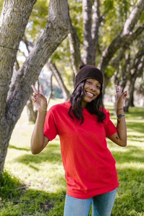 Smiling Woman in Red Crew Neck T-shirt and Black Knit Cap 