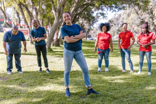 Happy group of adults participating in a fun outdoor team building activity in a park.
