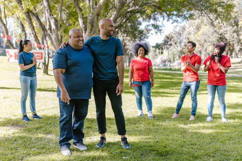 Men In Blue Shirts Standing With Arms Across Each Other