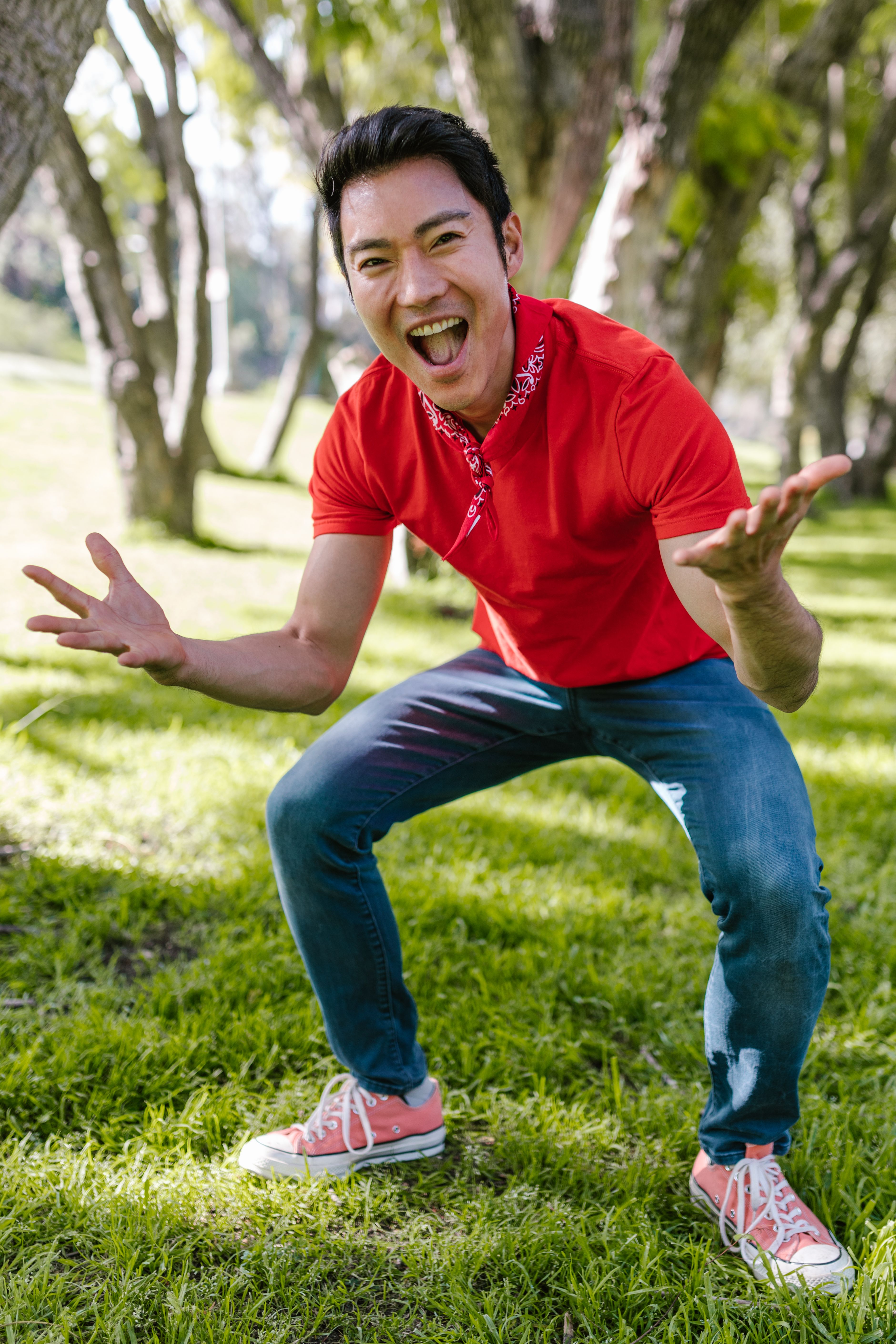 A cheerful adult male enjoying a sunny day in the park, expressing happiness and fun.
