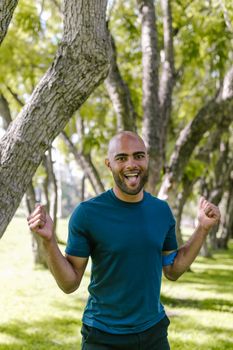 Vibrant scene of a joyful man in a park during daytime, exuding happiness and energy.