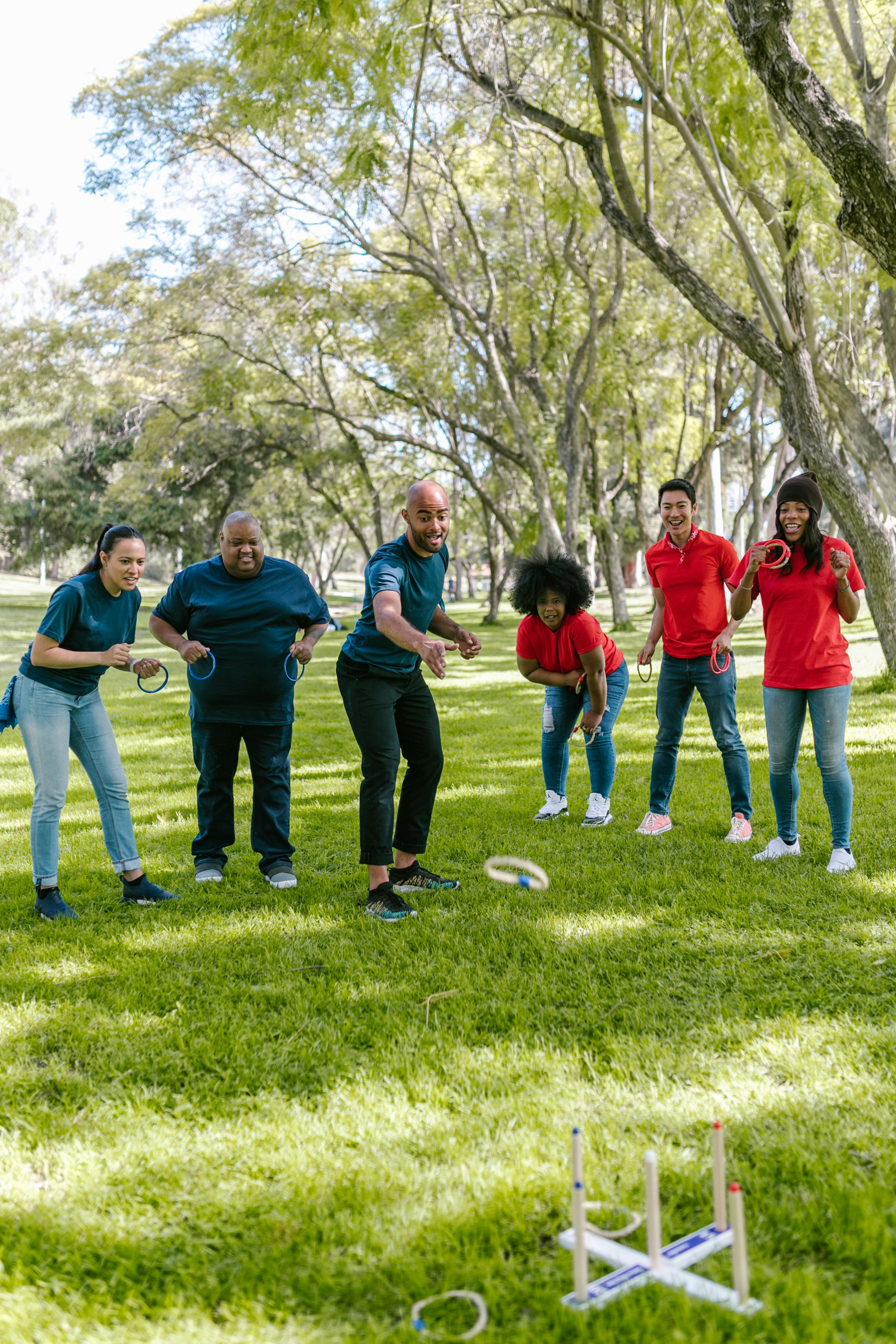 A diverse group of adults playing ring toss outdoors, showcasing teamwork and enjoyment.