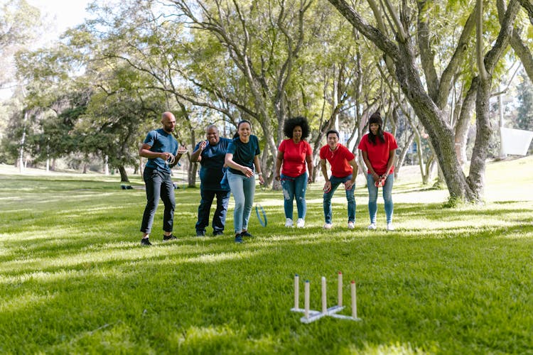 Group Of People Playing Ring Toss On Green Grass