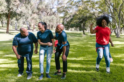 Free A joyful group of adults participating in a fun outdoor team-building exercise. Stock Photo