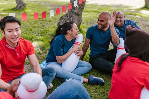 Free A multiracial group of adults enjoying outdoor team building activities with bowling pins. Stock Photo