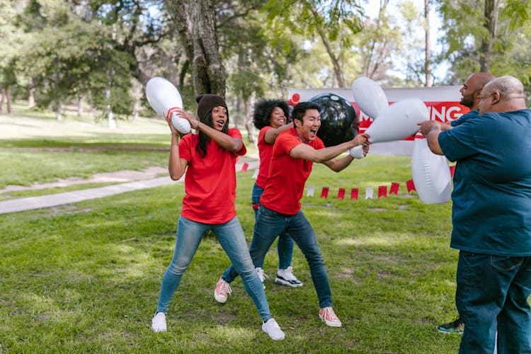 Group Of People Playing With Plastic Bowling Toy