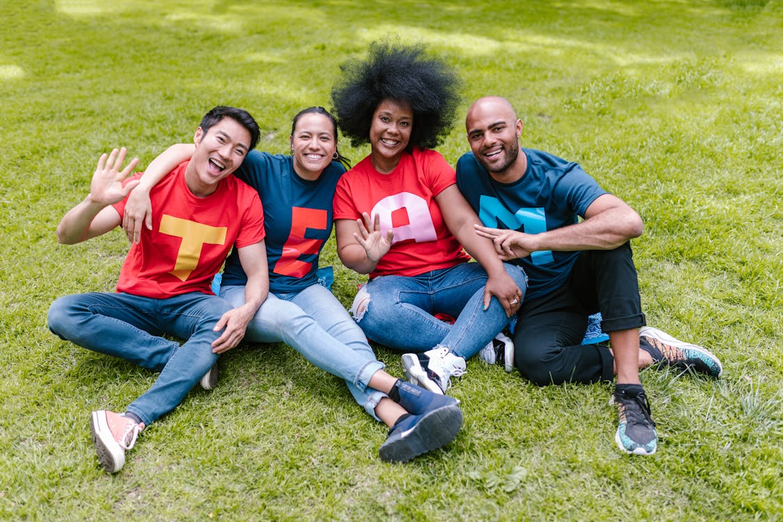 Free People Sitting On Grass With Happy Faces Stock Photo