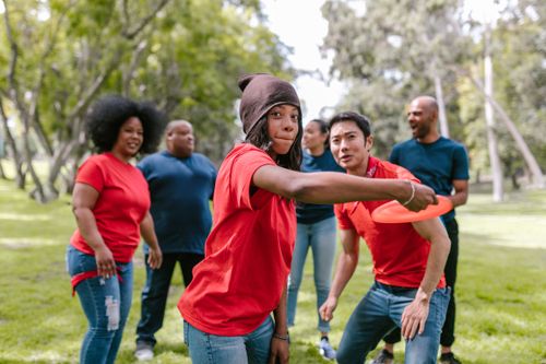 Free Diverse group of adults enjoying a frisbee game at the park, showcasing team spirit and fun. Stock Photo