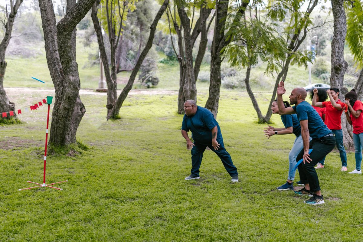 Black adults taking part in an outdoor team building game in a park