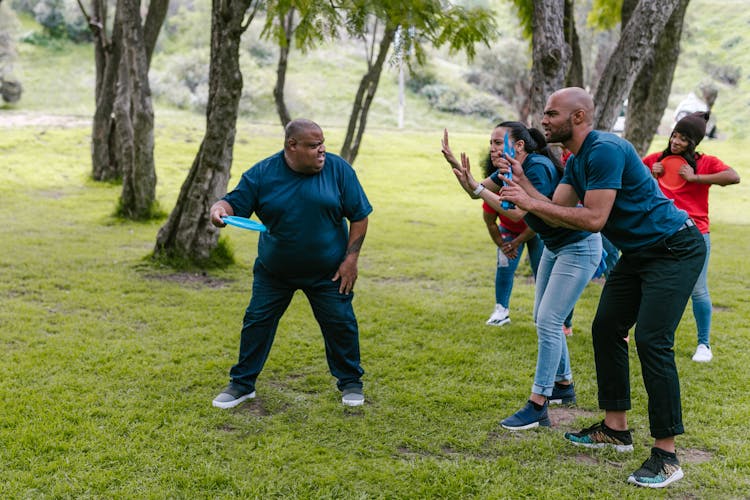 Group Of People Playing With Frisbee