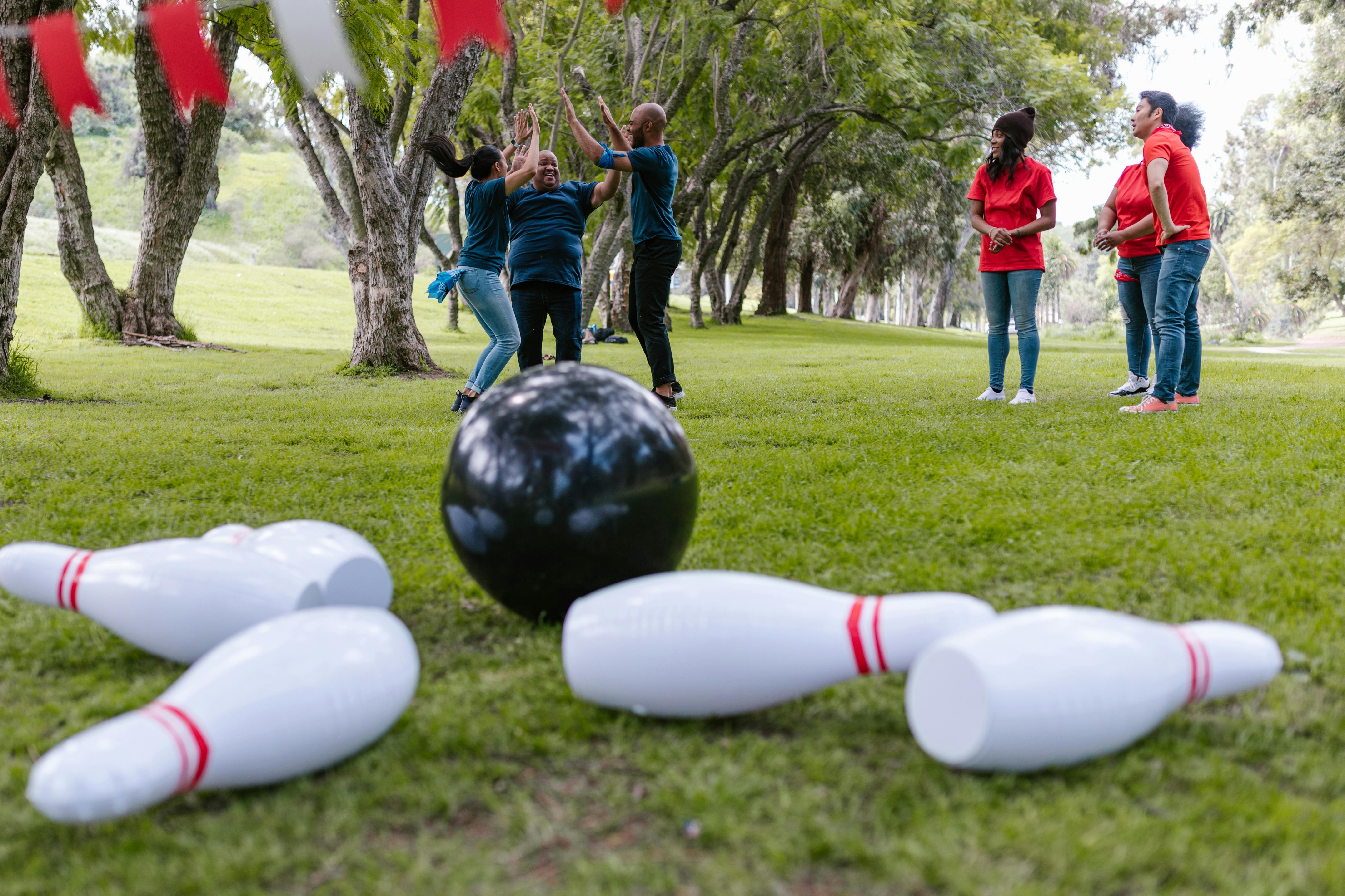 people playing bowling on green grass field