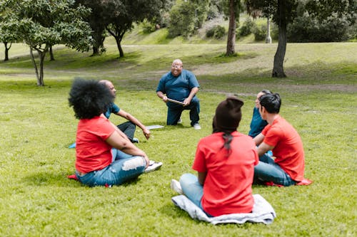 Free Group of People Sitting on Green Grass  Stock Photo