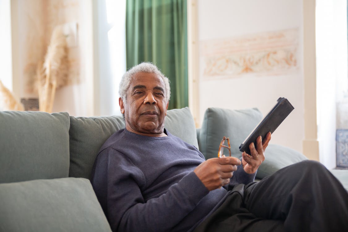 Free An Elderly Man in Black Sweater Holding a Digital Tablet Stock Photo