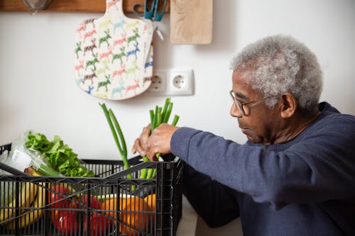 Free An Elderly Man in Sweater Holding Vegetables Stock Photo