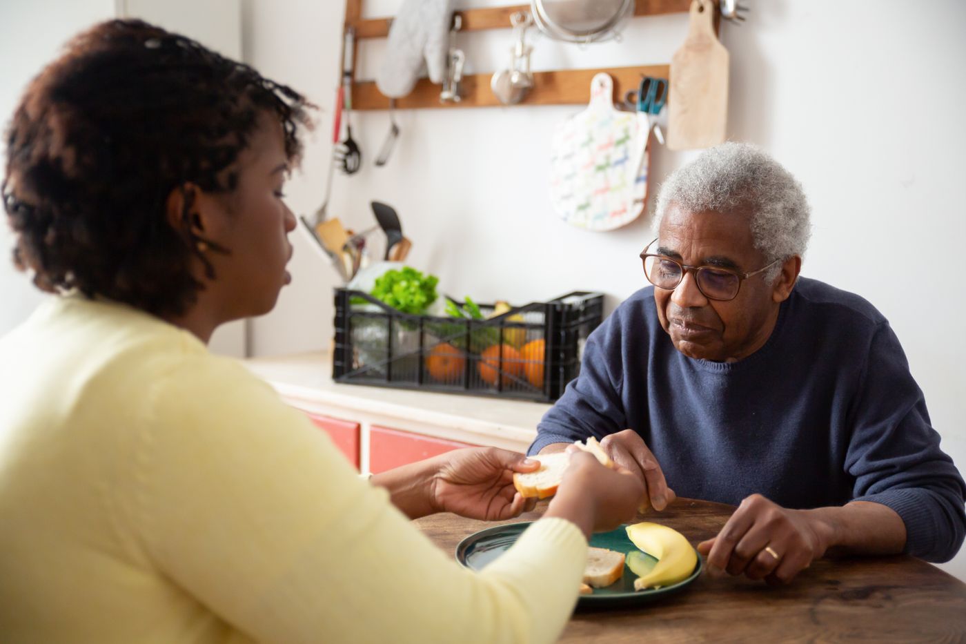 Caregiver assisting a client with a meal at home