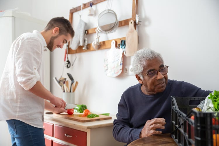 A Man Slicing Tomatoes In The Kitchen