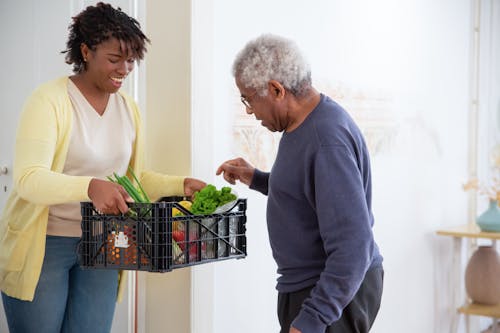 Free A Woman Holding a Plastic Crate with Fruits and Vegetables Stock Photo