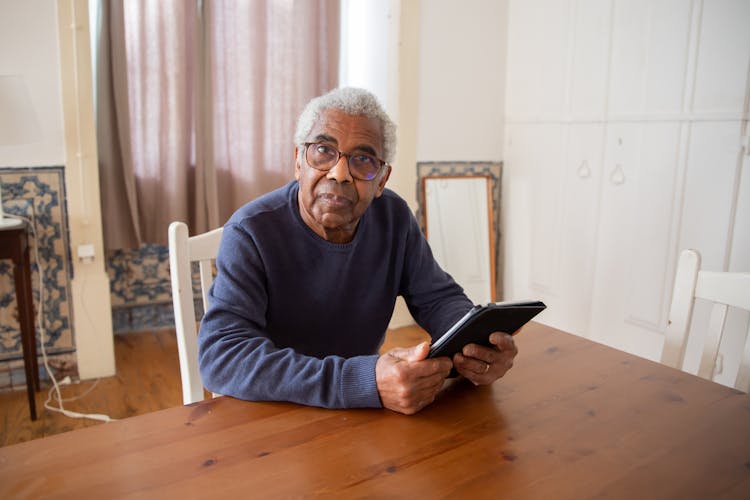 Elderly Man Holding A Tablet