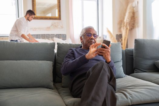 Man in Black Long Sleeve Shirt Sitting on Gray Couch
