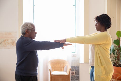 Free A Woman Teaching an Elderly Man Doing an Exercise Stock Photo