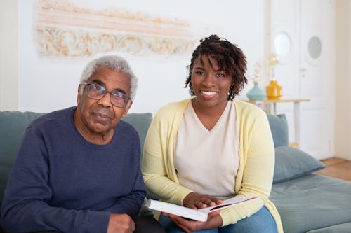 An Elderly Man in Blue Sweater Sitting Beside the Woman in Yellow Cardigan